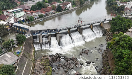 An aerial drone perspective reveals the historic Katulampa Dam spanning the Ciliwung River in Bogor 138253823