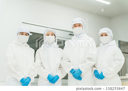 製造廠內穿著防護衣和清潔服工作的男女員工 138255647