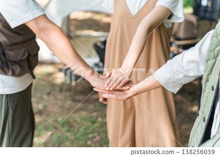 Friends, families, and friends standing together in a circle at a campsite Friends, families, and friends standing together in a circle at a campsite 138256039