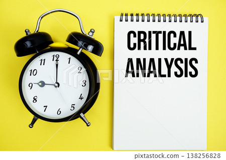 Critical Analysis text with alarm clock flat lay on yellow background 138256828