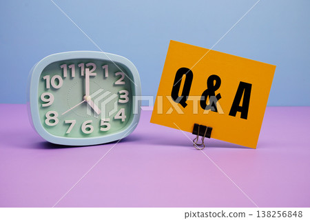 Q & A - Questions And Answers text and alarm clock on blue and purple background Q & A - Questions And Answers text and alarm clock on blue and purple background 138256848