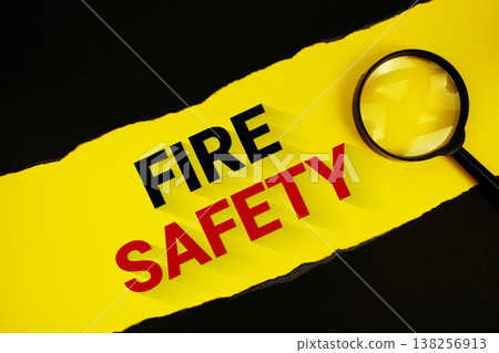 Fire Safety text on yellow with black paper torn ripped and magnifying glass Fire Safety text on yellow with black paper torn ripped and magnifying glass 138256913