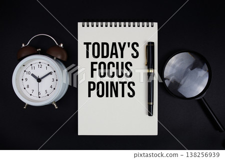 Today's Focus Points text written on notepad with alarm clock top view on black background Today's Focus Points text written on notepad with alarm clock top view on black background 138256939