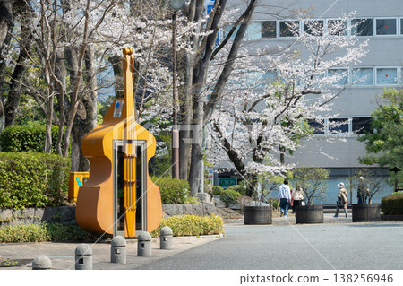 A double bass-shaped telephone booth installed in front of the concert hall. 138256946