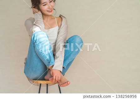 高腳椅,身穿牛仔服的女模特兒坐在椅子上 高腳椅,身穿牛仔服的女模特兒坐在椅子上 138256956