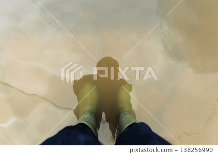 POV shot of person with Rain Boots standing in Floodwater. POV shot of person with Rain Boots standing in Floodwater. 138256990