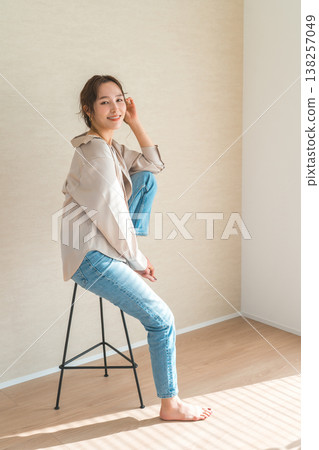 高腳椅，身穿牛仔服的女模特兒坐在椅子上 138257049