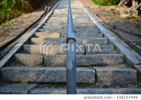 The old stone steps of the temple and the rusty handrail create a sense of depth and texture, reflecting the passage of time. The old stone steps of the temple and the rusty handrail create a sense of depth and texture, reflecting the passage of time. 138257449