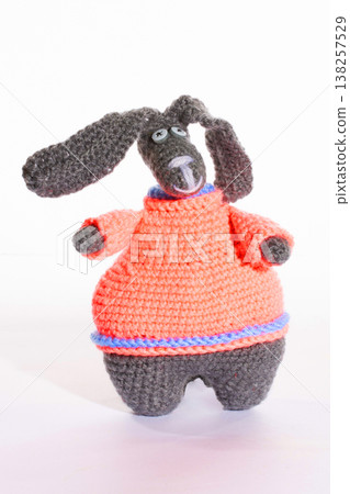 A funny rabbit crocheted from wool on a white background A funny rabbit crocheted from wool on a white background 138257529