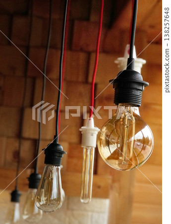 Vintage light bulbs suspended from a wire. Hanging retro incandescent lamps. closeup Vintage light bulbs suspended from a wire. Hanging retro incandescent lamps. closeup 138257648