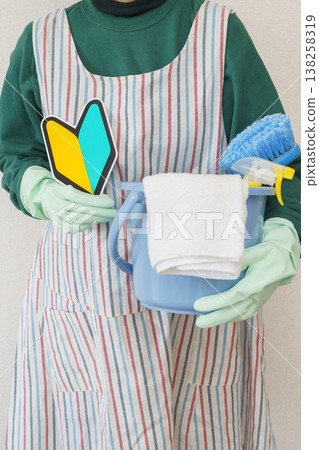 一位女士手持清潔工具，並貼有初學者貼紙 | 清潔和家務新手圖片。 138258319