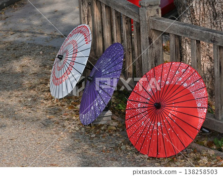 特寫:三把色彩鮮豔的日本雨傘並排擺放在木柵欄上。 特寫:三把色彩鮮豔的日本雨傘並排擺放在木柵欄上。 138258503