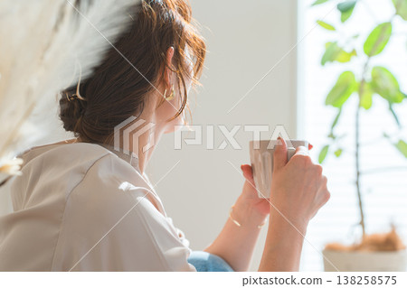 一位時尚女士在客廳喝熱飲。 138258575