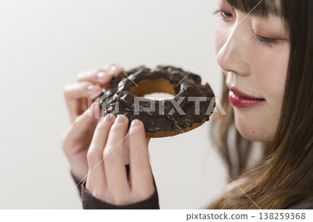 A woman eating a donut 138259368