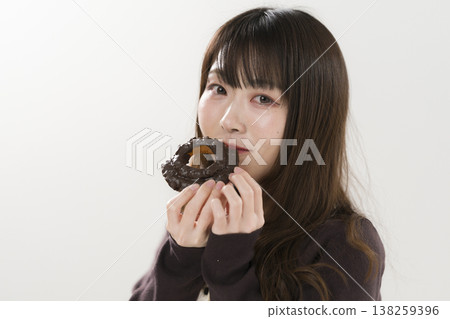 A woman eating a donut 138259396