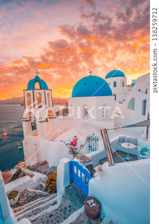 Stunning sunset Oia Santorini Greece, blue domes, radiant white architecture, picturesque Mediterranean travel background 138259712