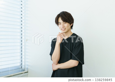 Portrait of a young Japanese man standing by a window Portrait of a young Japanese man standing by a window 138259845