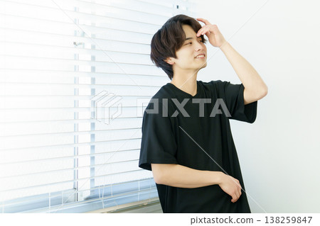 Portrait of a young Japanese man standing by a window Portrait of a young Japanese man standing by a window 138259847