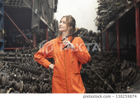 Technician female worker working in garage scrap yard old car part workshop warehouse. 138259874