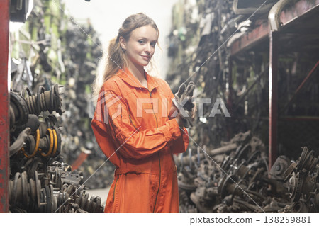 Technician female worker working in garage scrap yard old car part workshop warehouse. Technician female worker working in garage scrap yard old car part workshop warehouse. 138259881