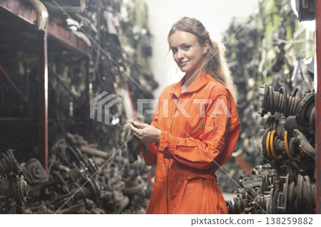 Technician female worker working in garage scrap yard old car part workshop warehouse. 138259882