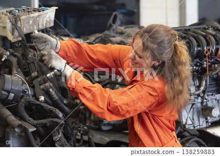 Technician female worker working in garage scrap yard old car part workshop warehouse. Technician female worker working in garage scrap yard old car part workshop warehouse. 138259883