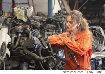 Technician female worker working in garage scrap yard old car part workshop warehouse. Technician female worker working in garage scrap yard old car part workshop warehouse. 138259885