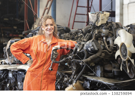 Technician female worker working in garage scrap yard old car part workshop warehouse. Technician female worker working in garage scrap yard old car part workshop warehouse. 138259894