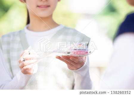 公園裡一個女孩在交換貼紙 138260352
