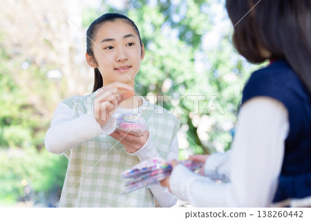 A girl exchanging stickers in the park 138260442