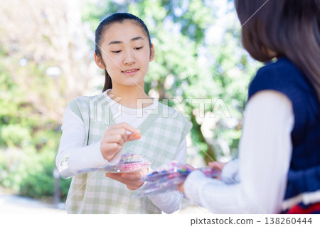 A girl exchanging stickers in the park 138260444
