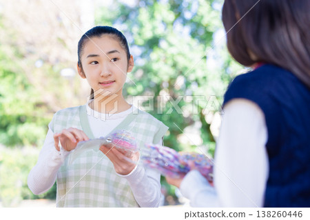 A girl exchanging stickers in the park 138260446