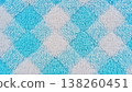 Close-up of a plush textile featuring a soft blue and white diamond pattern. Ideal as a cozy background, showcasing its fluffy texture and vibrant colors. 138260451