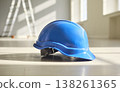 Blue hardhat on interior floor with sunlight, symbol of construction safety 138261365