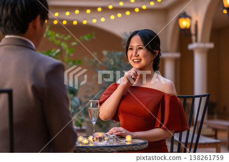 A couple in dresses, a married couple, happily chatting at dinner. 138261759