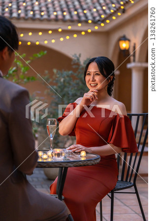 A couple in dresses, a married couple, happily chatting at dinner. 138261760