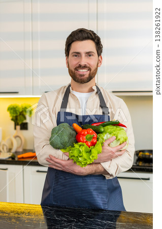 Middle-aged man holding fresh produce in kitchen promoting fit diet food for home cooking lifestyle Middle-aged man holding fresh produce in kitchen promoting fit diet food for home cooking lifestyle 138261922