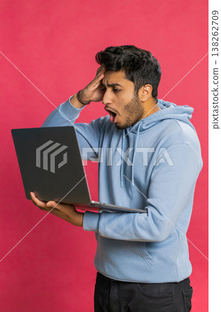 Displeased Indian man use laptop surprised by bad news, fortune loss, game fail, lottery results Displeased Indian man use laptop surprised by bad news, fortune loss, game fail, lottery results 138262709