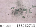 Peeling pink wall with cracked plaster and rough texture, weathered surface revealing gray cement underneath, abstract grunge background. 138262713