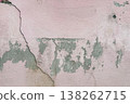 Peeling pink wall with cracked plaster and rough texture, weathered surface revealing gray cement underneath, abstract grunge background. 138262715