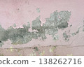 Peeling pink wall with cracked plaster and rough texture, weathered surface revealing gray cement underneath, abstract grunge background. 138262716