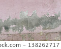 Peeling pink wall with cracked plaster and rough texture, weathered surface revealing gray cement underneath, abstract grunge background. 138262717