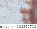Rusty metal surface with peeling paint, scratches, and oxidized textures, abstract industrial background with warm brown and pale blue tones. 138262718