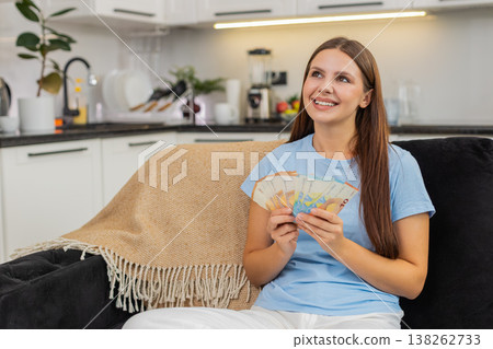 Young woman counts euro cash money plans big new purchase feels proud of savings salary and bonus Young woman counts euro cash money plans big new purchase feels proud of savings salary and bonus 138262733