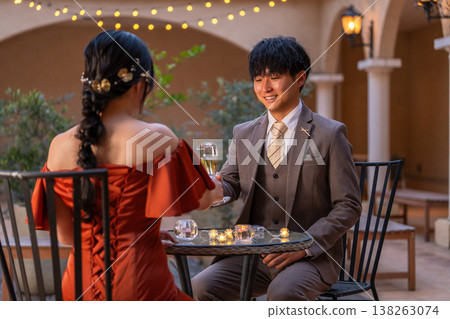一對新人穿著晚宴婚禮禮服，在晚餐時喝香檳。 138263074