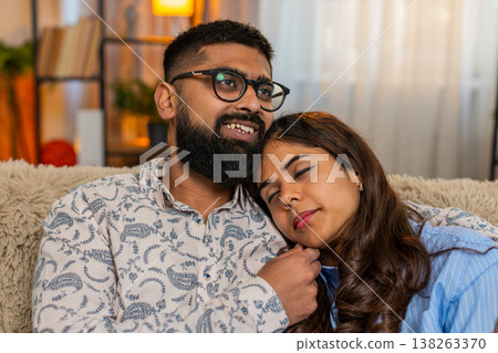 Indian couple man woman sleeping at home, girl resting on shoulder while boy touches hair gently 138263370