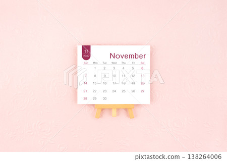 November 2027 calendar page with wooden easel on pink background. November 2027 calendar page with wooden easel on pink background. 138264006