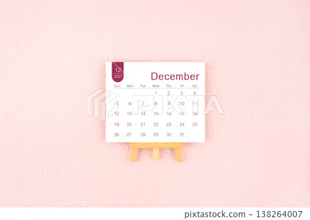 December 2027 calendar page with wooden easel on pink background. December 2027 calendar page with wooden easel on pink background. 138264007