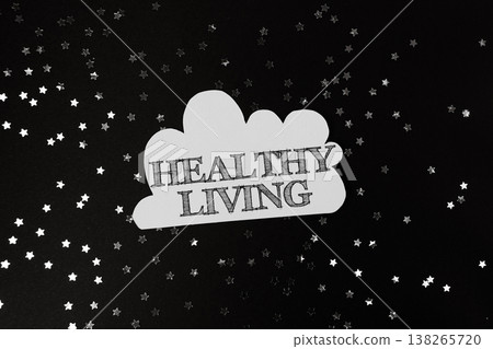 Healthy living concept with cloud-shaped text on a dark background, surrounded by scattered silver stars, symbolizing wellness and positive lifestyle choices 138265720