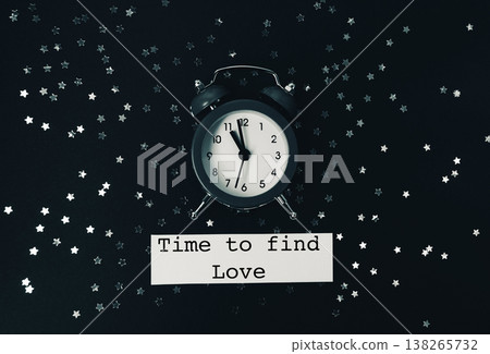 Vintage alarm clock surrounded by silver star confetti on a dark background, conveying the message of love and the passage of time, perfect for romantic themes and celebrations 138265732